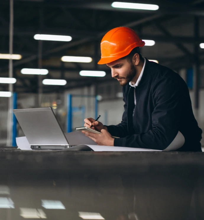 Engineer checking manufacturing data on a laptop